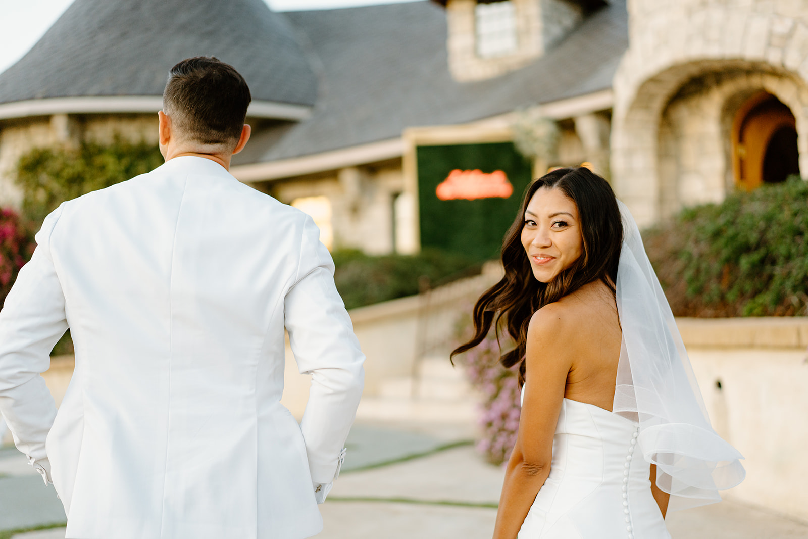 Bride looks back as newly weds walk away at Chateau Noland wedding in San Luis Obispo California - Cobblestone
