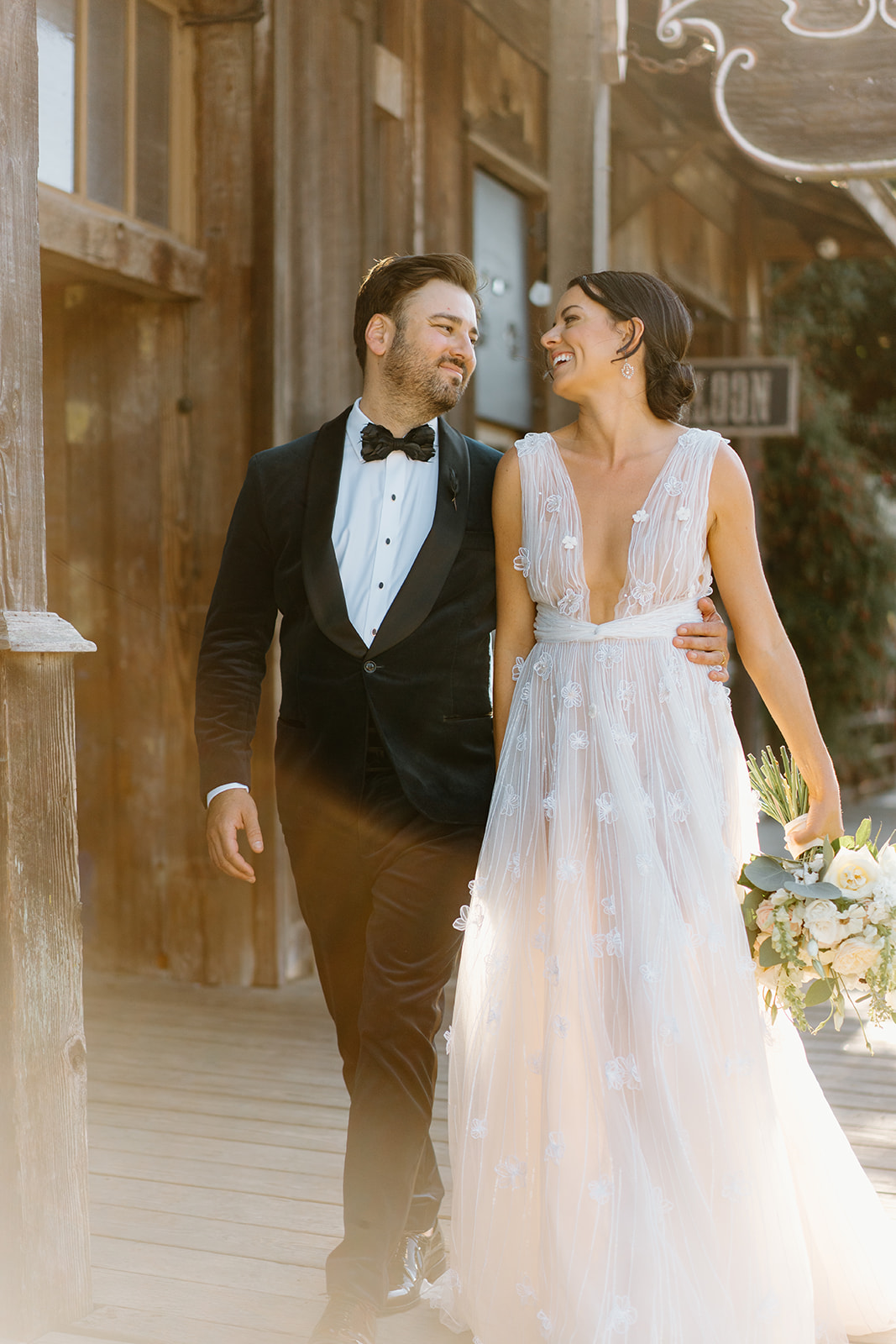 bride and groom laugh outside 1880 Union Hotel in Los Alamos, Ca photography by Cobblestone