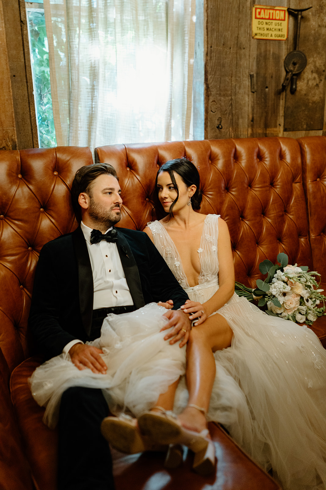 bride and groom cuddle on couch at 1880 Union Hotel in Los Alamos, Ca photography by Cobblestone