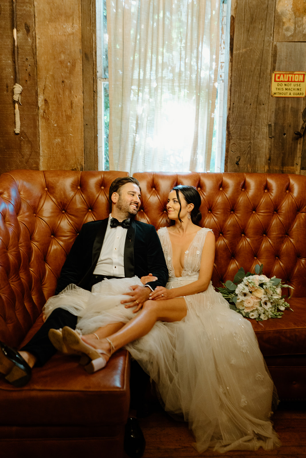 bride and groom cuddle on couch at 1880 Union Hotel in Los Alamos, Ca photography by Cobblestone