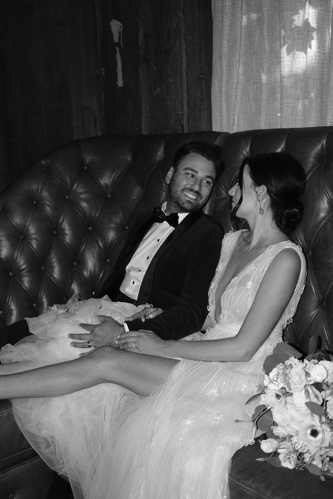 bride and groom cuddle on couch at 1880 Union Hotel in Los Alamos, Ca photography by Cobblestone
