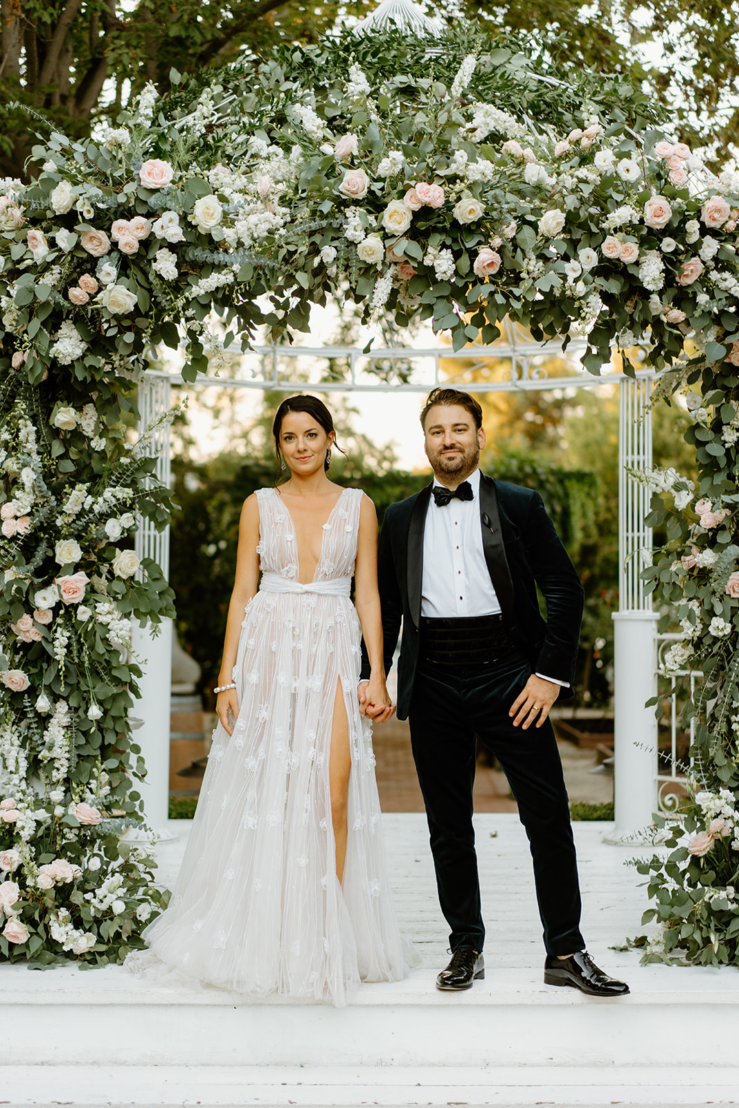 bride and groom under flower arch at 1880 Union Hotel in Los Alamos, Ca photography by Cobblestone