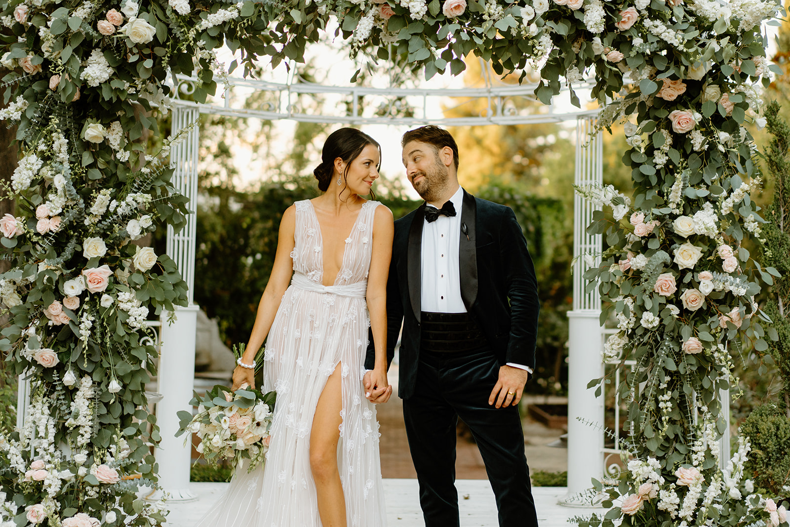 bride and groom under flower arch at 1880 Union Hotel in Los Alamos, Ca photography by Cobblestone