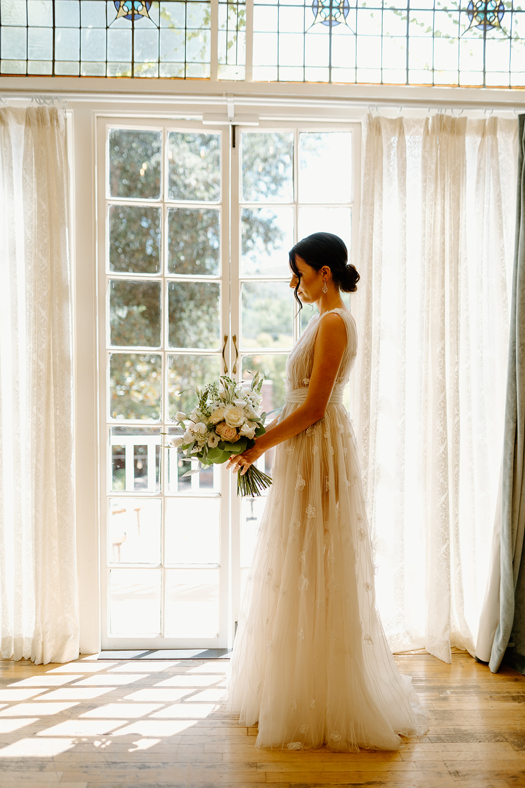 bride looks out window at wedding at 1880 Union Hotel in Los Alamos, Ca photography by Cobblestone