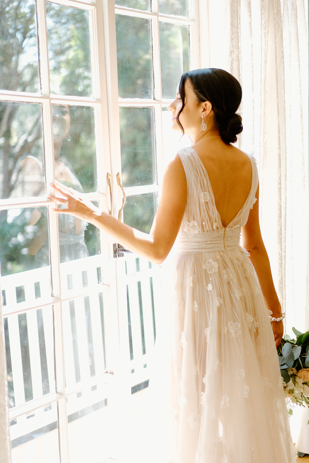 bride looks out window at wedding at 1880 Union Hotel in Los Alamos, Ca photography by Cobblestone