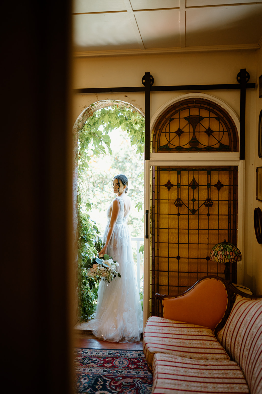 bride looks out window at wedding at 1880 Union Hotel in Los Alamos, Ca photography by Cobblestone
