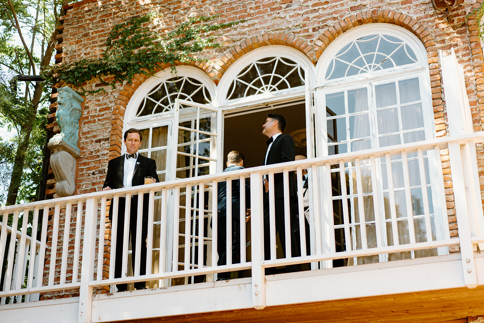groomsmen on balcony at wedding at 1880 Union Hotel in Los Alamos, Ca photography by Cobblestone