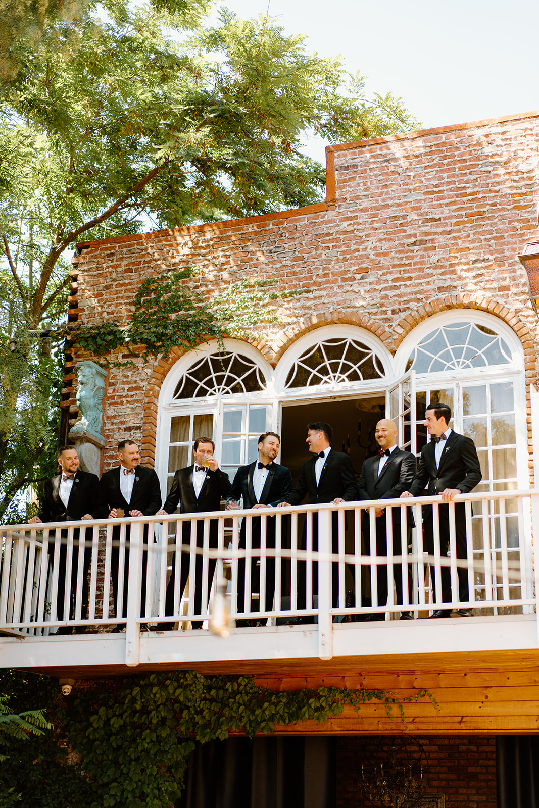 groomsmen on balcony at wedding at 1880 Union Hotel in Los Alamos, Ca photography by Cobblestone