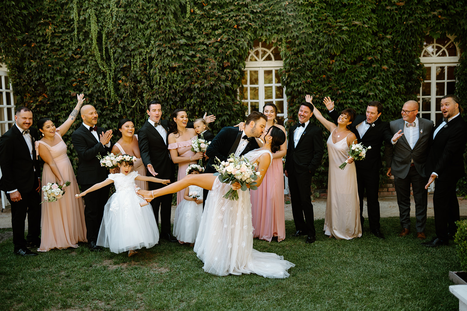bridal party with bride and groom kissing at 1880 Union Hotel in Los Alamos, Ca photography by Cobblestone