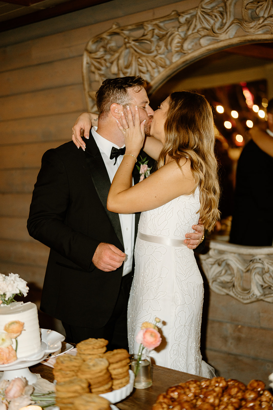 bride and groom kiss after cake cutting at wedding at Botanica, Oceanside California, photography by Cobblestone