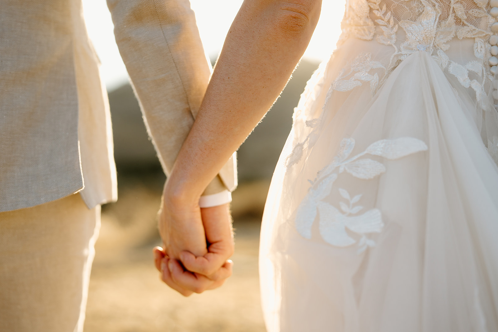 bride and groom hold hands on hilltop at Higuera Ranch, San Luis Obispo CA, photography by Cobblestone