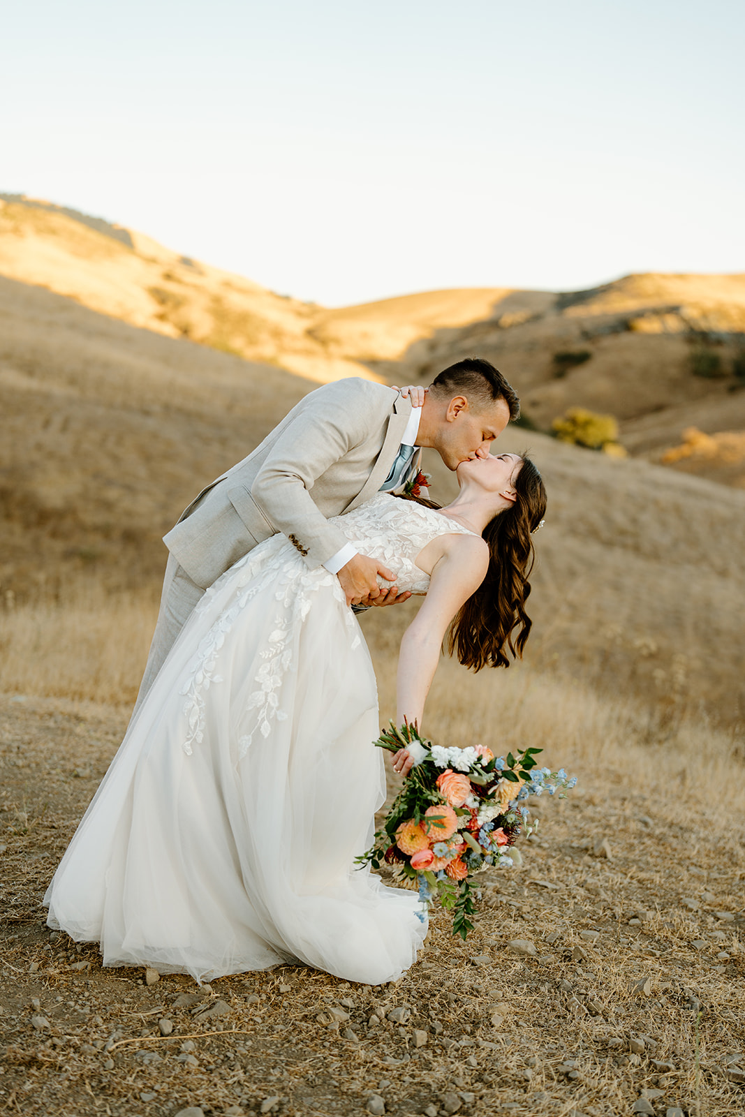 bride and groom kiss on hilltop at Higuera Ranch, San Luis Obispo CA, photography by Cobblestone