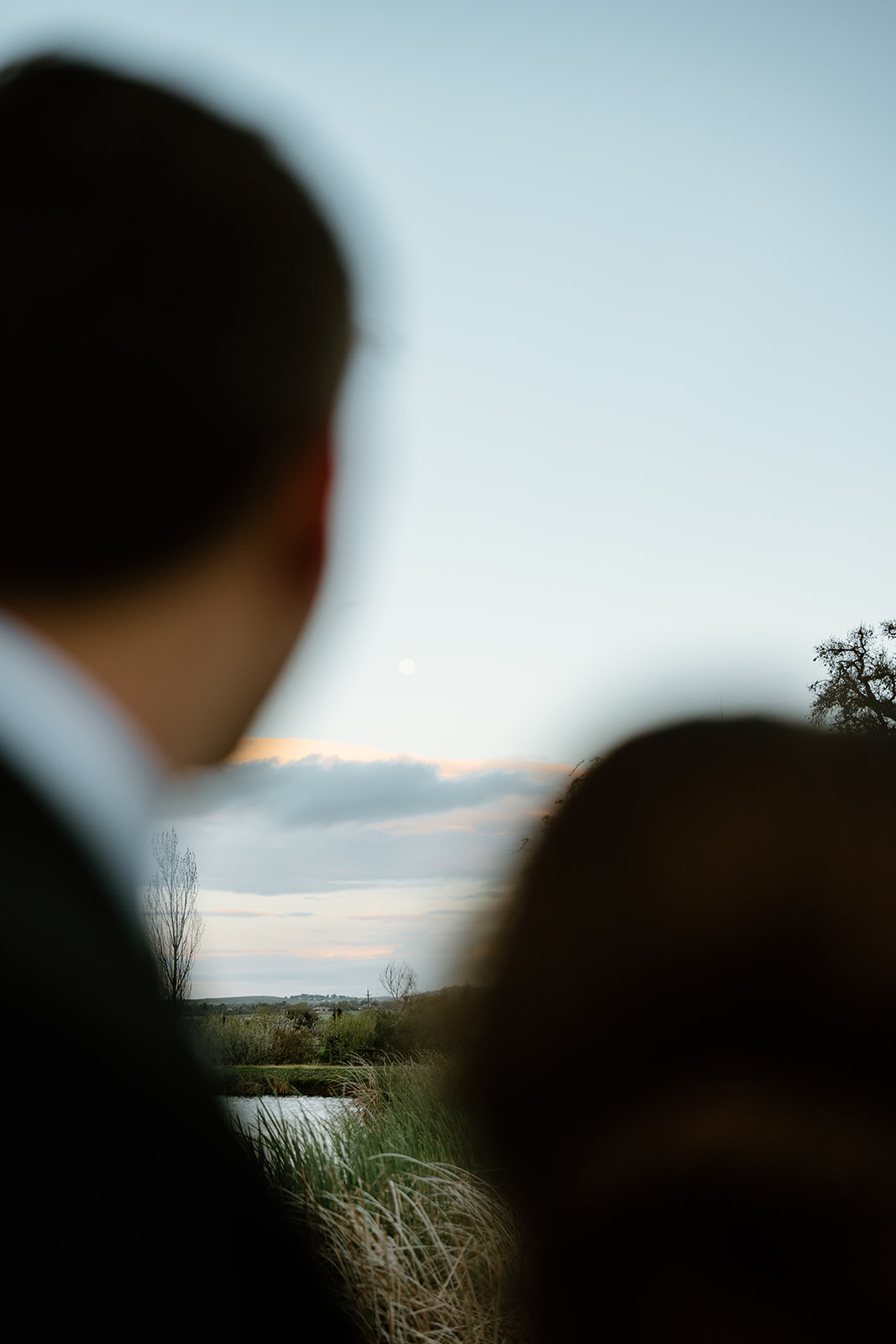 bride and groom look out at moon after wedding in San Luis Obispo CA, photography by Cobblestone