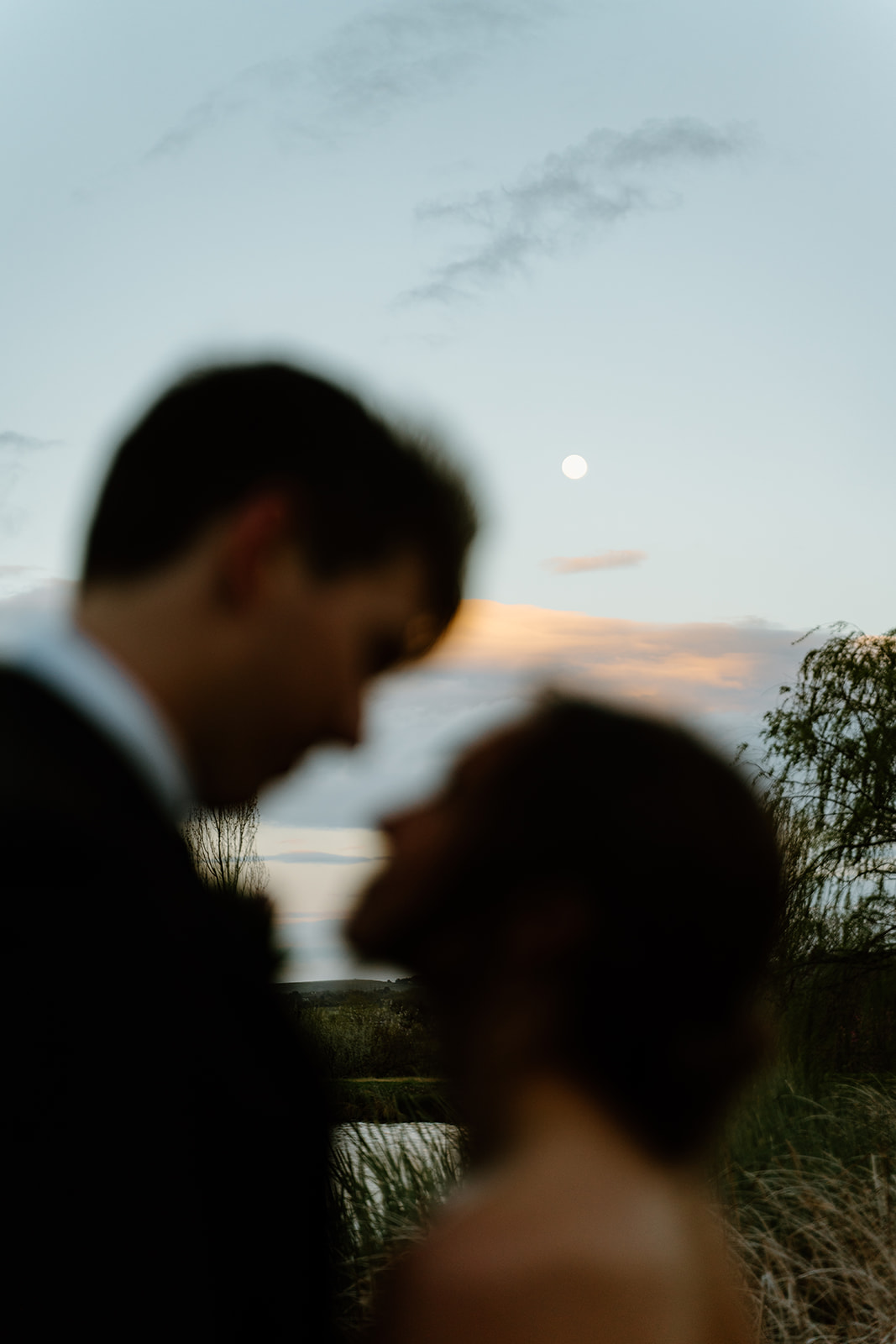 bride and groom look out at moon after wedding in San Luis Obispo CA, photography by Cobblestone