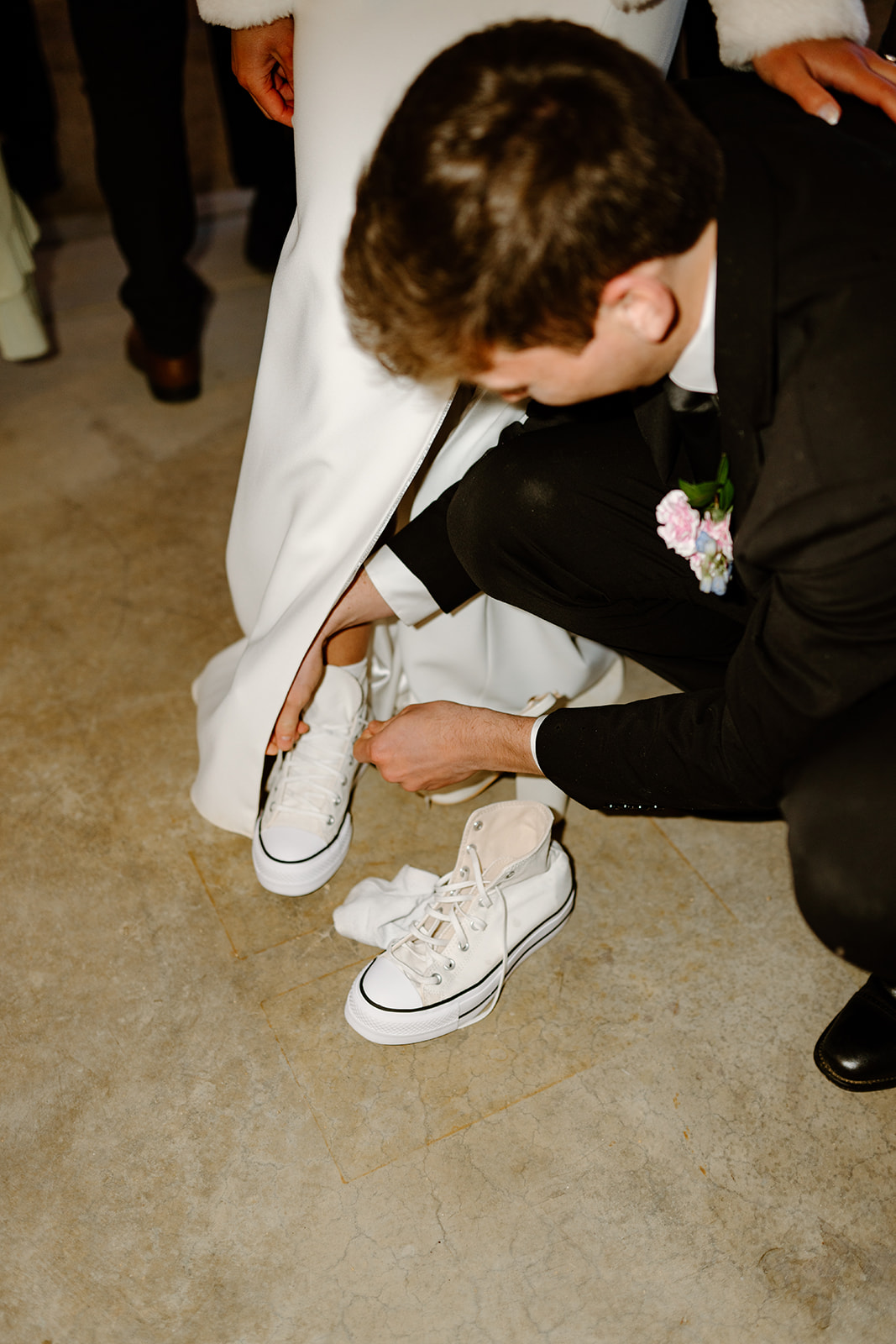 groom helps bride with shoes at wedding in San Luis Obispo CA, photography by Cobblestone