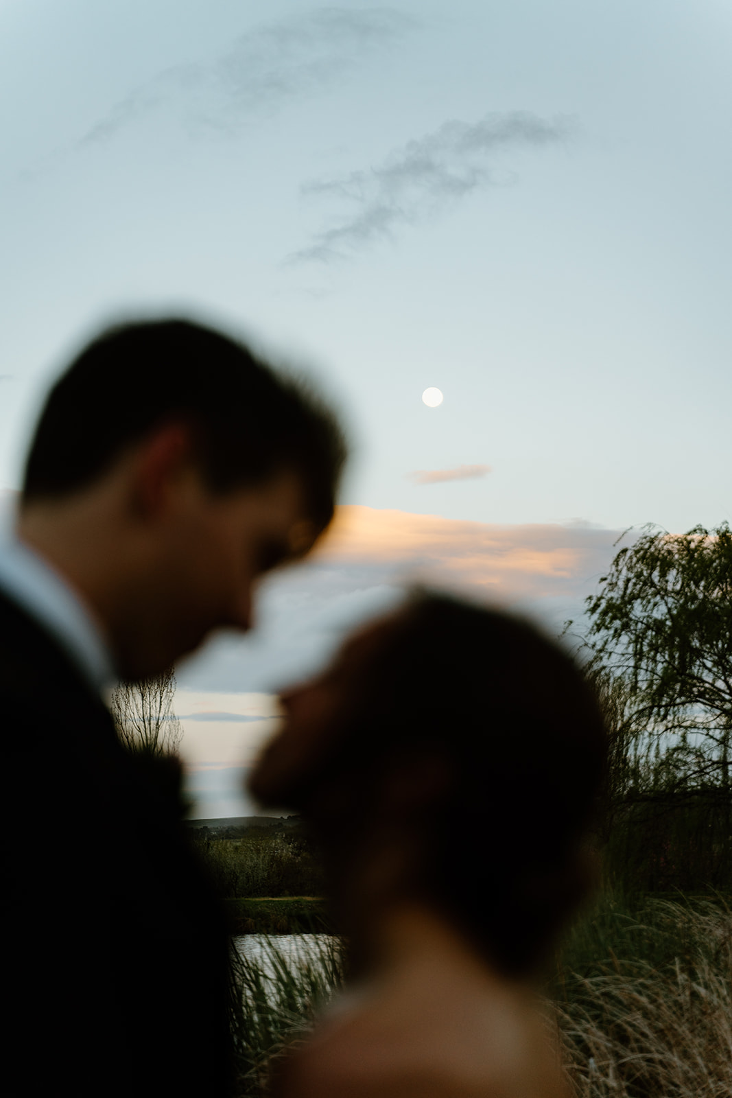 Bride and groom look embrace under the moon at Willow and Oak in Creston CA