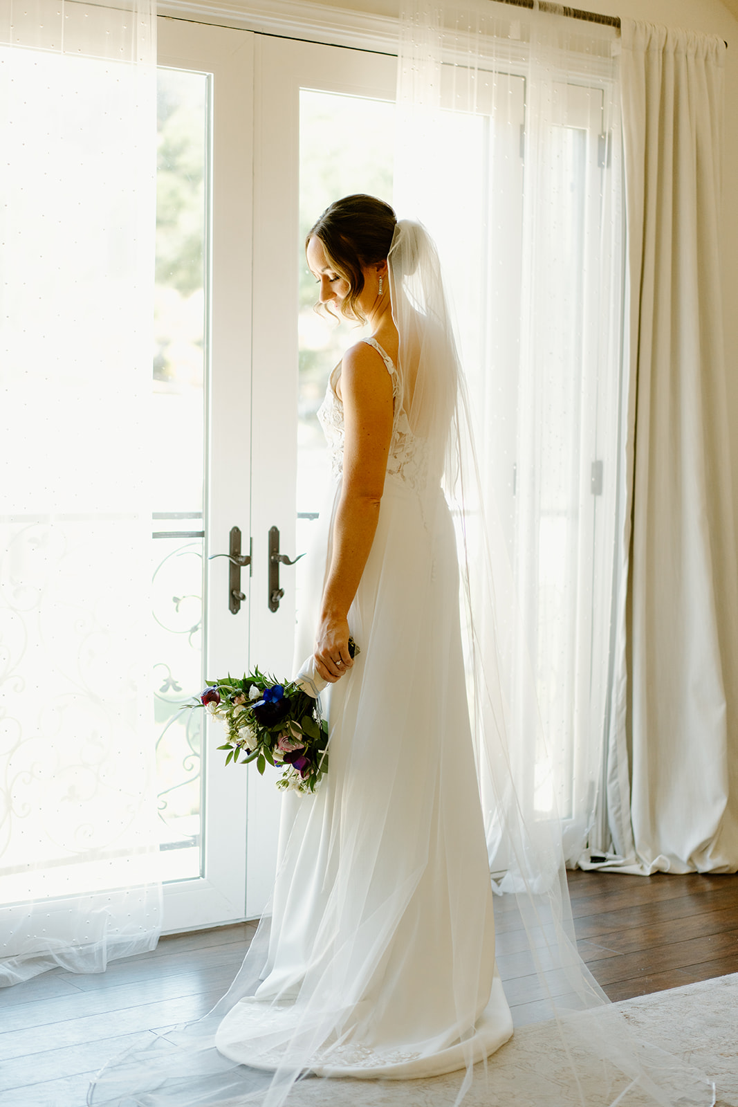 bride looks out window at wedding in San Luis Obispo CA, photography by Cobblestone