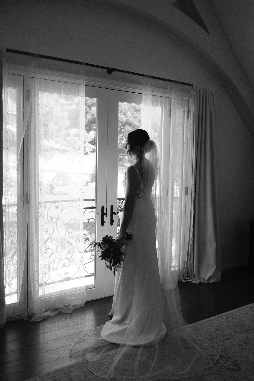 bride looks out window at wedding in San Luis Obispo CA, photography by Cobblestone